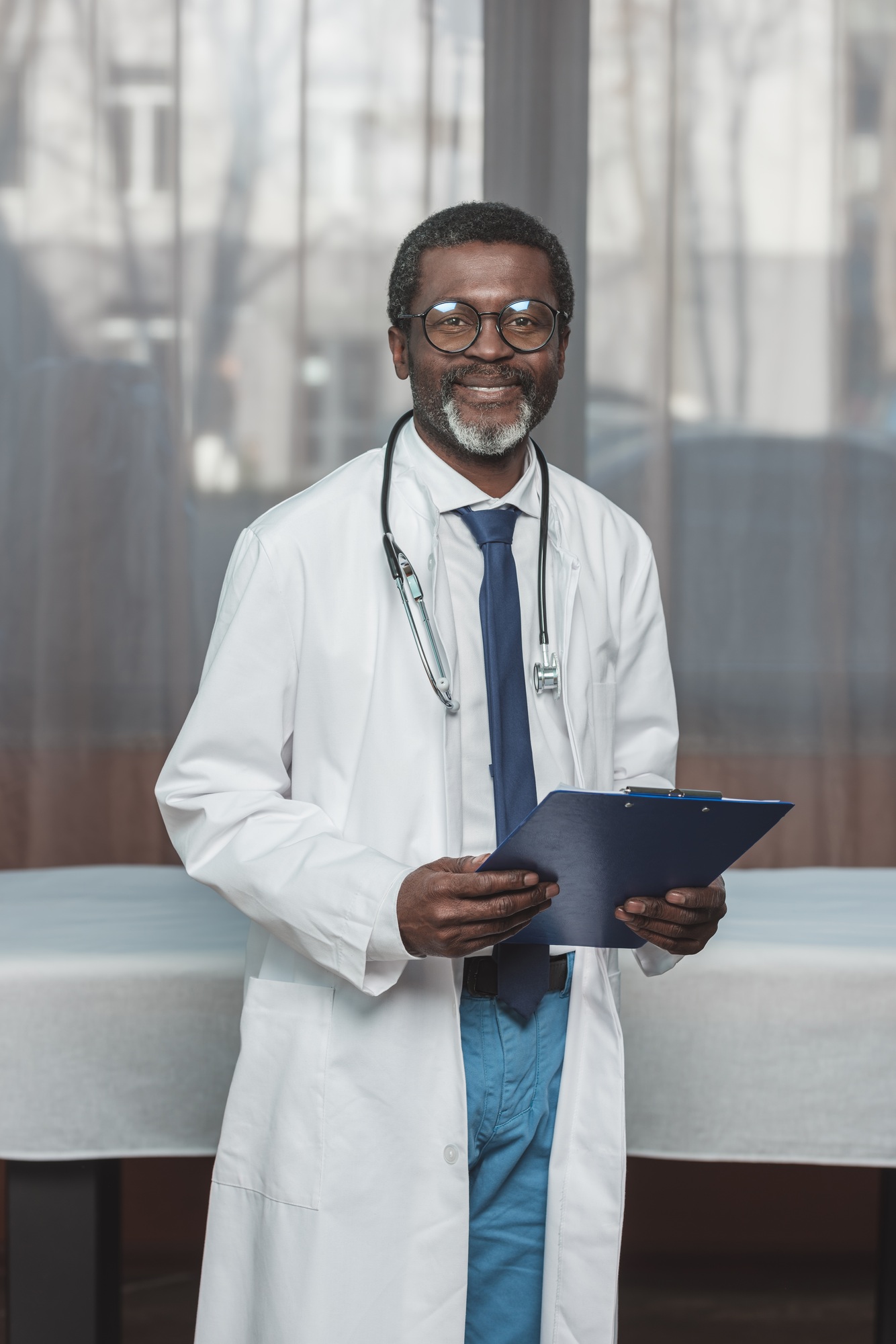 Smiling african american doctor standing with clipboard